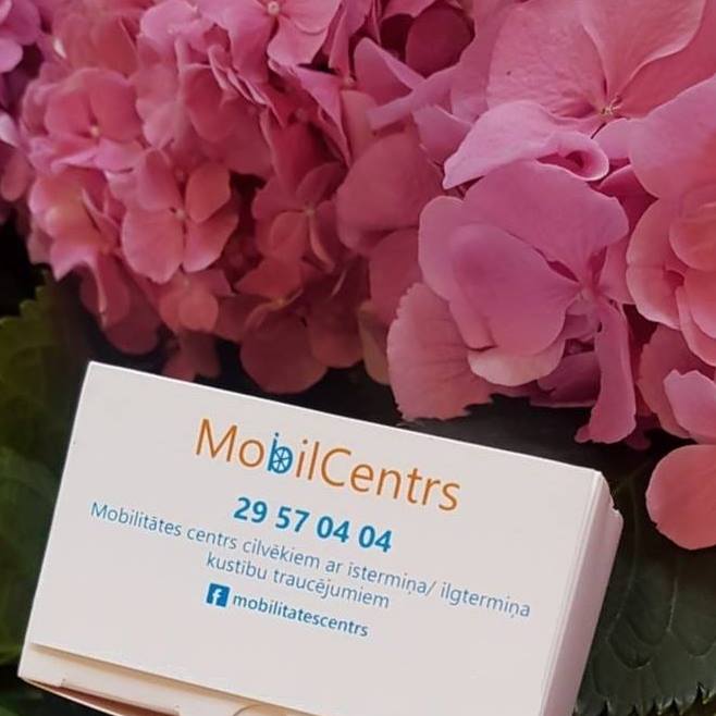 Vizītkarte ar uzņēmuma"MobilCentrs" nosaukumu un kontaktinformāciju ziedu fona priekšā.