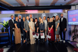 Grupas bilde uz skatuves ar visiem piču fināla dalībniekiem, pasākuma moderatoru un žūriju.