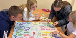 $ kids sitting around the table and playing game